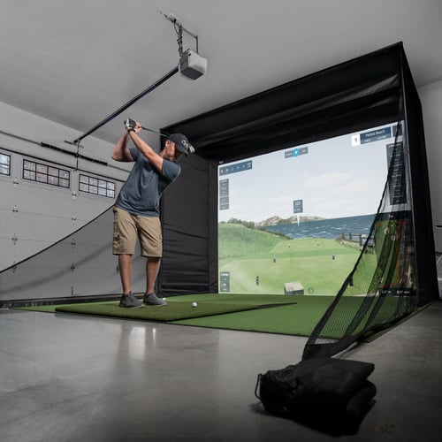 Carl's DIY golf simulator enclosure in a garage with safety baffles