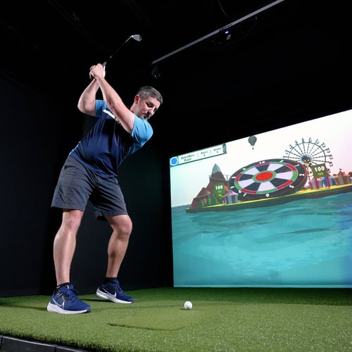 Carl's Pro golf simulator enclosure with golfer and overhead launch monitor